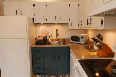 a kitchen with white cabinets and a sink and a microwave at Lake Naomi Chalet - 2hrs from NYC in Pocono Pines