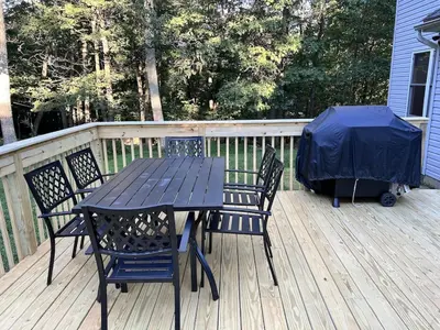 a picnic table and chairs on a deck at AMAZING Home with PRIVATE POOL, GAME ROOM & FIRE PIT! in East Stroudsburg
