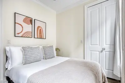 a white bedroom with a white bed with two pillows at Nolita 1br w wd nr New Museum NYC-1037 in New York