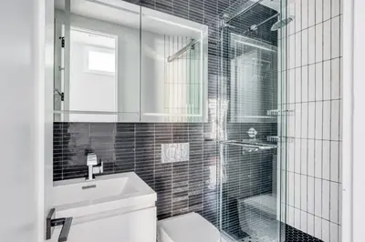 a bathroom with a shower and a toilet and a sink at West Village 3br w wd nr Pier 46 NYC-1098 in New York
