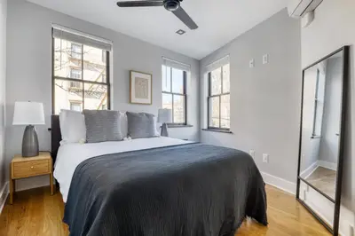 a bedroom with a large bed and two windows at West Village 3br w wd nr Pier 46 NYC-1098 in New York