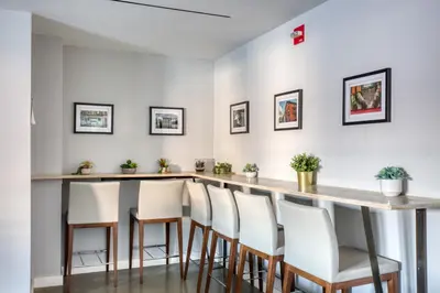 a kitchen with a bar with white stools at Hoboken 2BR w PATH Shuttle Gym WD NYC-813 in Hoboken
