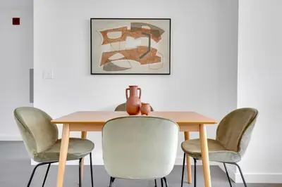 a dining room table with chairs and a vase on it at Hoboken 2BR w PATH Shuttle Gym WD NYC-813 in Hoboken