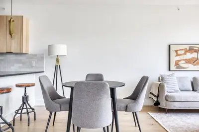 a living room with a table and chairs and a couch at Jersey City 2BR w wd roof gym nr Path NYC-962 in Jersey City