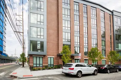 a white car parked in front of a brick building at Jersey City 2BR w wd roof gym nr Path NYC-962 in Jersey City
