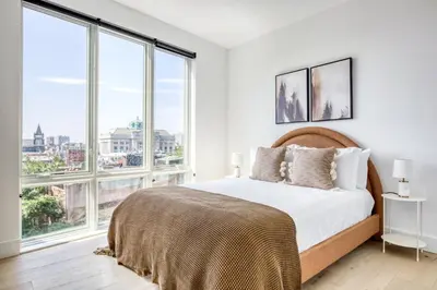 a bedroom with a bed and large windows at Jersey City 2BR w wd roof gym nr Path NYC-962 in Jersey City