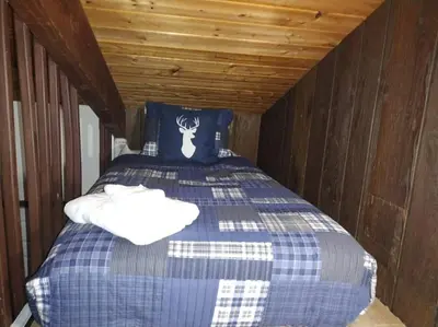 a bedroom with a bed with a blue and white comforter at Poconos Pool Paradise in East Stroudsburg