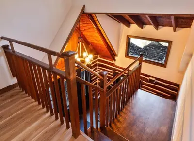 a wooden staircase in a house with a window at Poconos Pool Paradise in East Stroudsburg