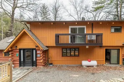 a log home with a balcony and a deck at Poconos Pool Paradise in East Stroudsburg