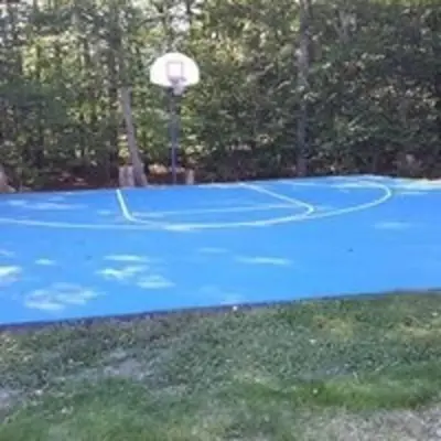 a basketball hoop on a blue tennis court at The Family Getaway in Tobyhanna