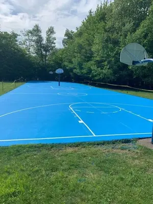 a blue tennis court with a basketball hoop on it at The Family Getaway in Tobyhanna