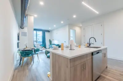 a kitchen with a counter and a dining room at Emerald Escape, Free Parking, 2 Bath, Sleeps 8 Near American Dream and The Airport, King Bed and 2 Queen Beds, Washer and Dryer in Orange