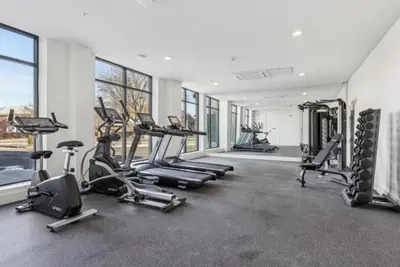 a gym with a bunch of treadmills and machines at Emerald Escape, Free Parking, 2 Bath, Sleeps 8 Near American Dream and The Airport, King Bed and 2 Queen Beds, Washer and Dryer in Orange