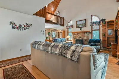 a bedroom with a large bed and a living room at Wolf Hollow Harmony in Lake Harmony