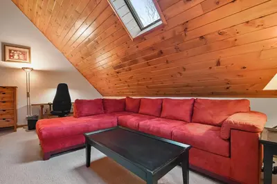 a living room with a red couch and a table at Wolf Hollow Harmony in Lake Harmony
