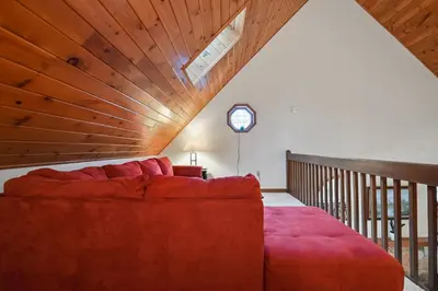 a red couch in a room with a wooden ceiling at Wolf Hollow Harmony in Lake Harmony