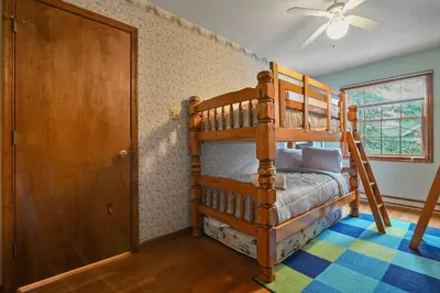 a bedroom with two bunk beds and a door at Wolf Hollow Harmony in Lake Harmony
