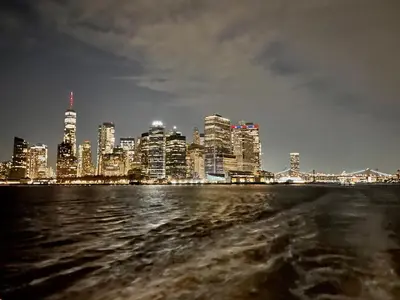 a view of a city from the water at night at New York City Private Bedroom Near The Free Ferry Boat! in Stapleton