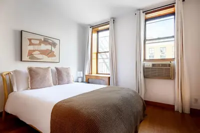 a bedroom with a large bed and two windows at Nolita 2br w wd nr SoHo NYC-992 in New York