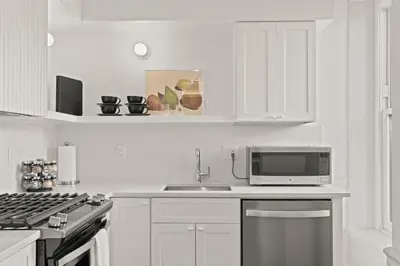 a white kitchen with a sink and a microwave at Stay Rafa At 2000 Spruce in Philadelphia