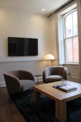 a living room with two chairs and a table and a tv at Stay Rafa At 2000 Spruce in Philadelphia