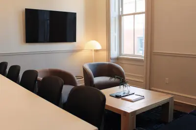 a waiting room with chairs and a table and a tv at Stay Rafa At 2000 Spruce in Philadelphia