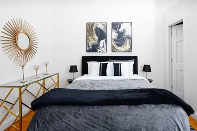 a bedroom with a large bed and a mirror at Spacious studio in Brooklyn Heights in Brooklyn