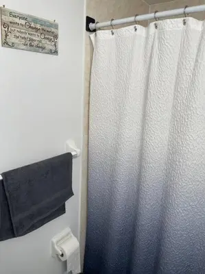 a bathroom with a shower curtain and a toilet at Modern one bedroom apartment in Princes Bay