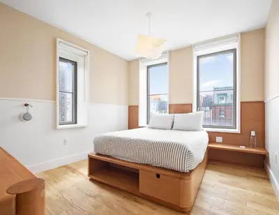 a bedroom with a bed and two windows at UNTITLED at 3 Freeman Alley in New York