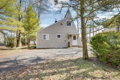 a white house with a white door and a tree at Dock and Sunroom Waterfront Home Near Kalahari! in Pocono Summit
