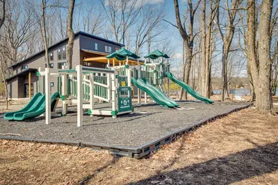 a playground with slides in front of a house at Dock and Sunroom Waterfront Home Near Kalahari! in Pocono Summit