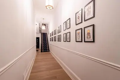 a hallway with a bunch of pictures on the wall at Thena Hotel- Lux Studio in Philadelphia