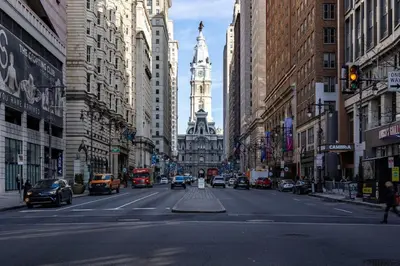 a busy city street with a clock tower in the distance at Thena Hotel - Ground Floor 1 Bedroom Suite in Philadelphia