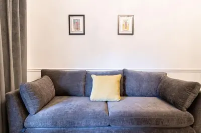 a blue couch with a yellow pillow on it at Thena Hotel - Ground Floor 1 Bedroom Suite in Philadelphia
