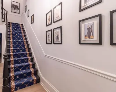a staircase with framed pictures on the wall at Thena Hotel - Oversized 1 Bedroom in Philadelphia