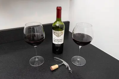 two wine glasses and a bottle of wine on a counter at Thena Hotel - Large Studio in Philadelphia