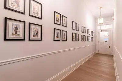 a hallway with framed pictures on a wall at Thena Hotel - Spacious Studio in Philadelphia