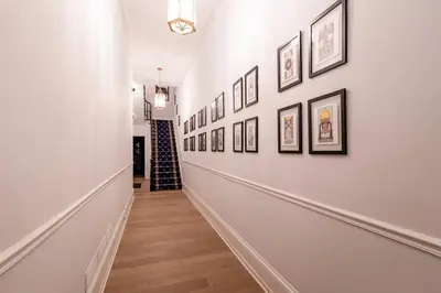 a hallway with a bunch of pictures on the wall at Thena Hotel - Spacious Studio in Philadelphia