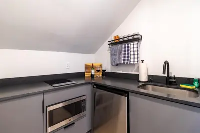 a kitchen with a sink and a microwave at Thena Hotel - Spacious Studio in Philadelphia