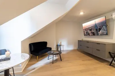 a living room with a black chair and a table at Thena Hotel - Spacious Studio in Philadelphia