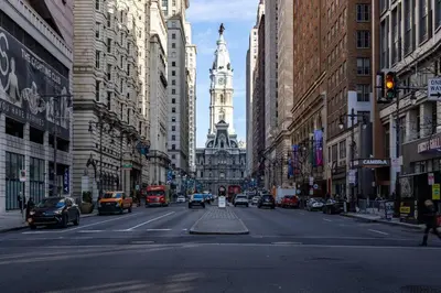 a busy city street with a clock tower in the distance at Thena Hotel - Spacious Studio in Philadelphia