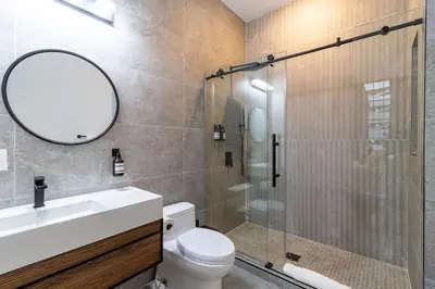 a bathroom with a shower and a toilet and a mirror at Thena Hotel - Cozy Studio in Philadelphia