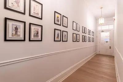 a hallway with framed pictures on the wall at Thena Hotel - Beautiful 1 Bedroom in Philadelphia