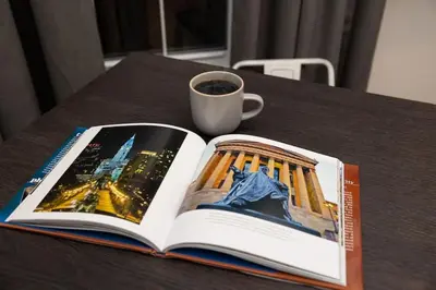 an open book on a table with a cup of coffee at Thena Hotel - Beautiful 1 Bedroom in Philadelphia