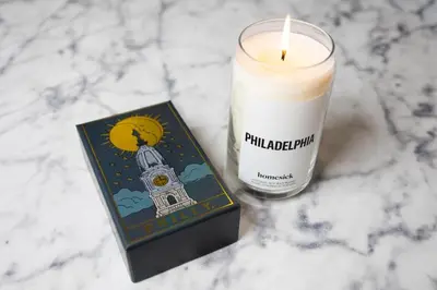 a candle and a book on a marble table at Thena Hotel 2nd Floor Studio Unit4 in Philadelphia