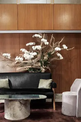 a living room with a couch and a painting of flowers at The Prince Kitano New York in New York