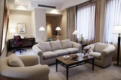 a living room with a couch and chairs and a table at The Prince Kitano New York in New York