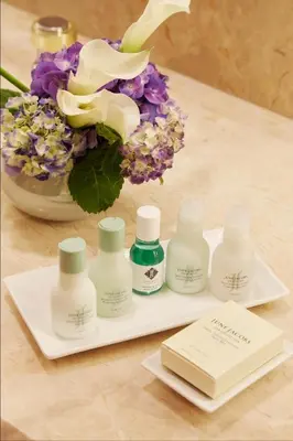 a group of four bottles of lotion on a table at The Prince Kitano New York in New York