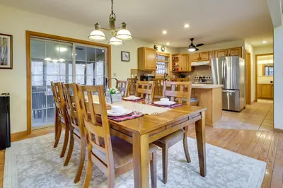 a kitchen and dining room with a wooden table and chairs at Hot Tub, Game Room! Poconos Home 22 Mi to Slopes in Gouldsboro