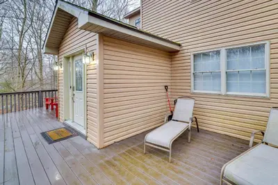 a wooden deck with two chairs and a house at Hot Tub, Game Room! Poconos Home 22 Mi to Slopes in Gouldsboro